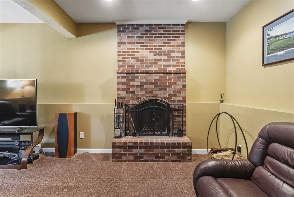67 Roxy Cahoon Road Plymouth, MA 02360 - Photo 23 of 37 a living room with furniture a flat screen tv and a fireplace
