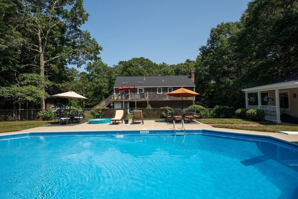67 Roxy Cahoon Road Plymouth, MA 02360 - Photo 31 of 37 a view of a swimming pool with lawn chairs under an umbrella