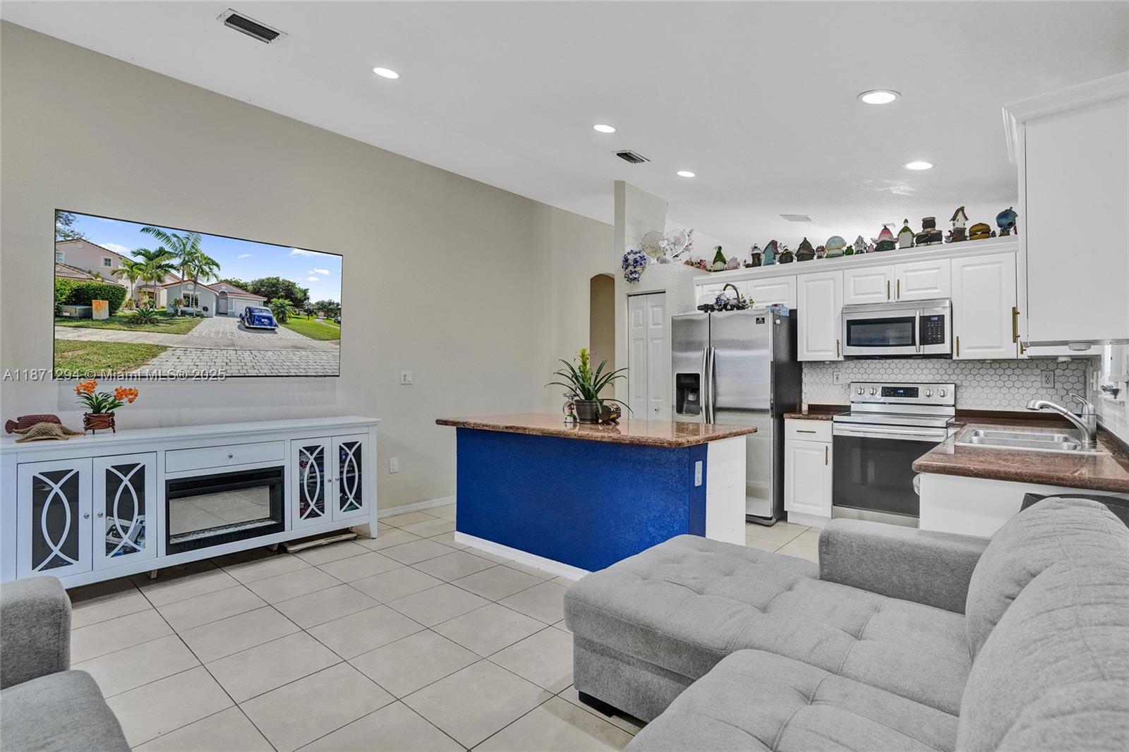 1635 Southeast 20th Place Homestead, FL 33035 - Photo 12 of 19 a kitchen with stainless steel appliances kitchen island granite countertop a stove a sink and a microwave