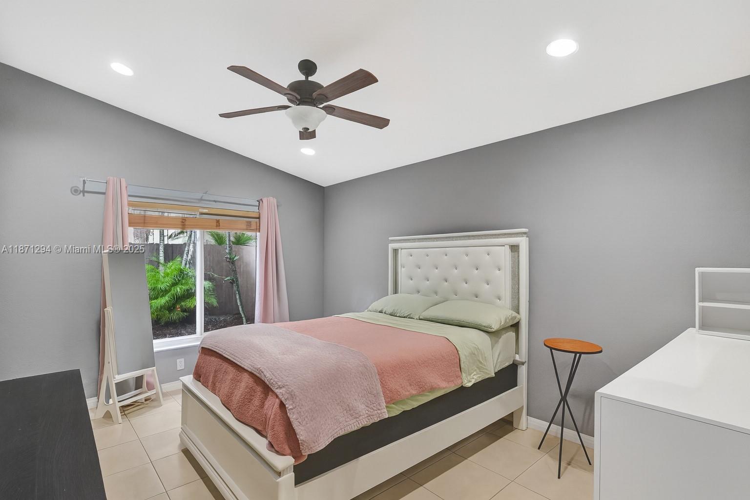 1635 Southeast 20th Place Homestead, FL 33035 - Photo 16 of 19 a bedroom with a large bed and a chandelier