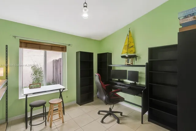 a view of a workspace with furniture and a window