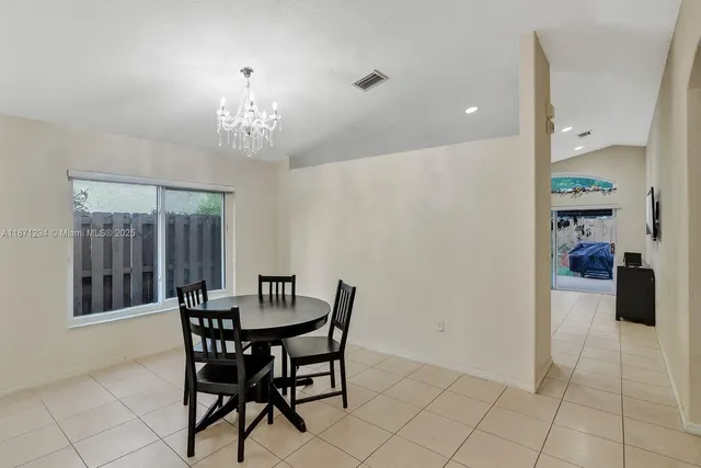 a view of a dining room with furniture and chandelier