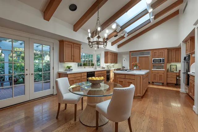 a dining room with furniture a chandelier and wooden floor