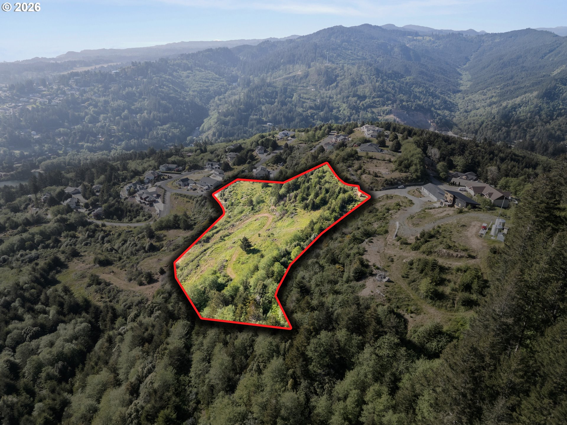 Dale Court, Unit 2 Brookings, OR 97415 - Photo 1 of 13 an aerial view of a house with a yard and mountain view