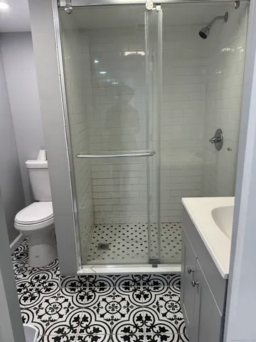 a bathroom with a sink a toilet a window and shower