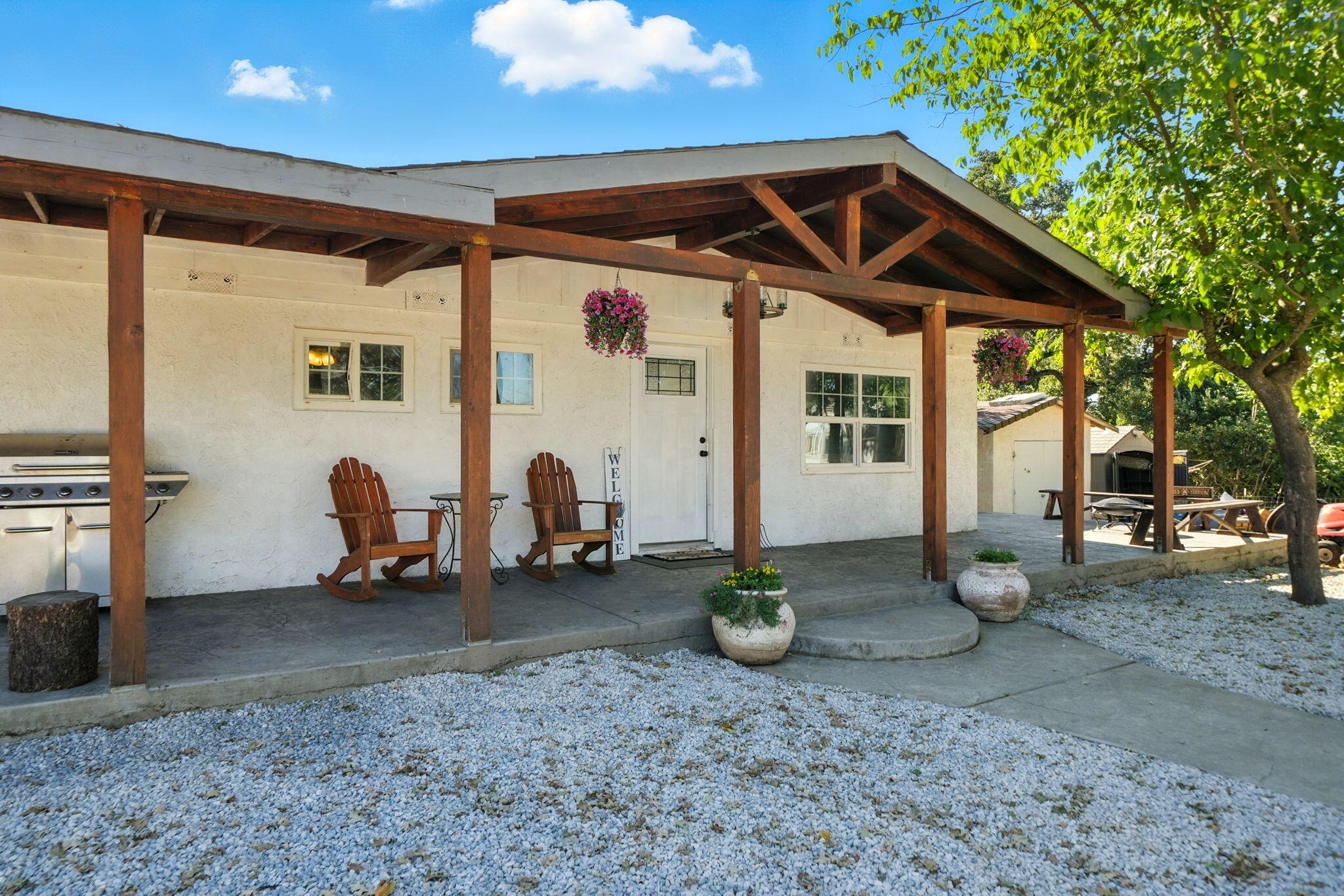 22945 Adobe Road Cottonwood, CA 96022 - Photo 6 of 40 a view of a wooden house with two chairs and a potted plant