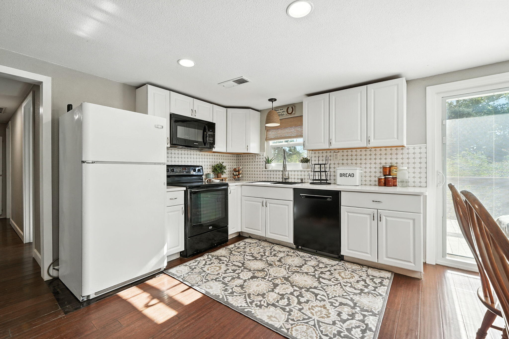 22945 Adobe Road Cottonwood, CA 96022 - Photo 9 of 40 a kitchen with a refrigerator stove and white cabinets