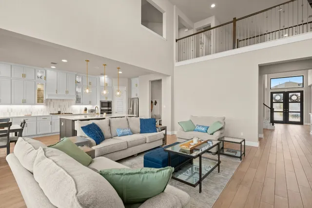 a living room with furniture wooden floor and a kitchen view