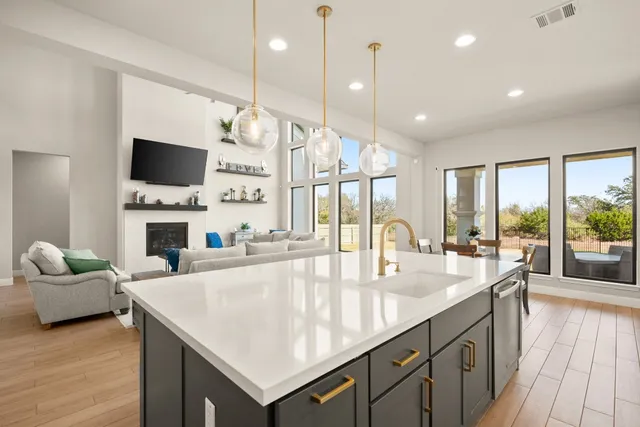 a large kitchen with sink a counter space and living room view