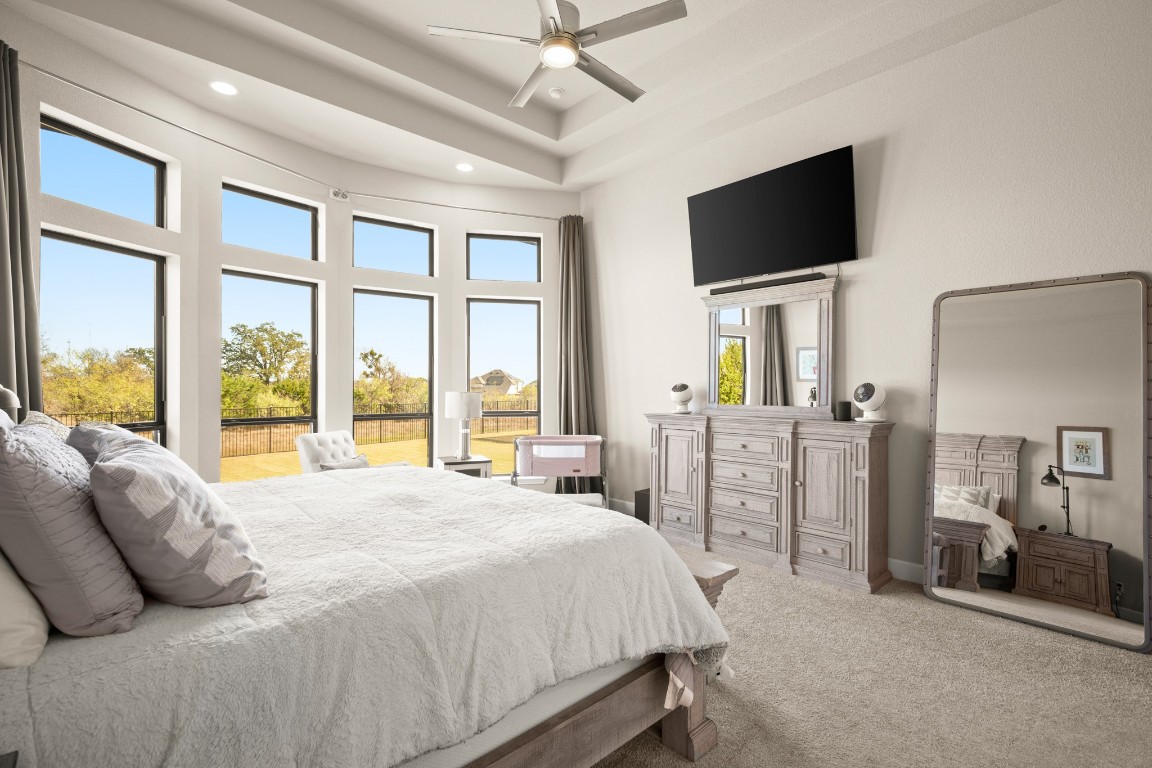 108 Rosetta Loop Liberty Hill, TX 78642 - Photo 18 of 40 a bedroom with a bed flat screen tv and a large window