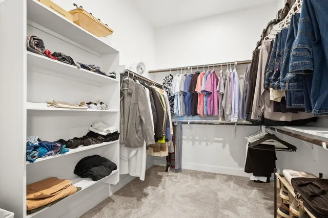 a view of walk in closet with clothes and shoes