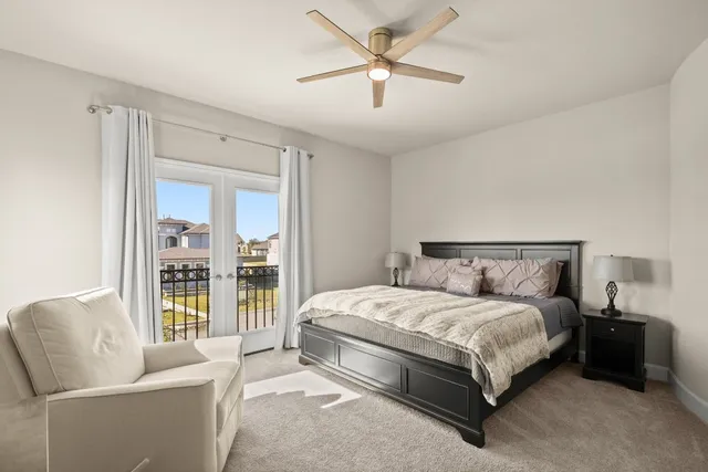 a bedroom with a bed couch and a large window