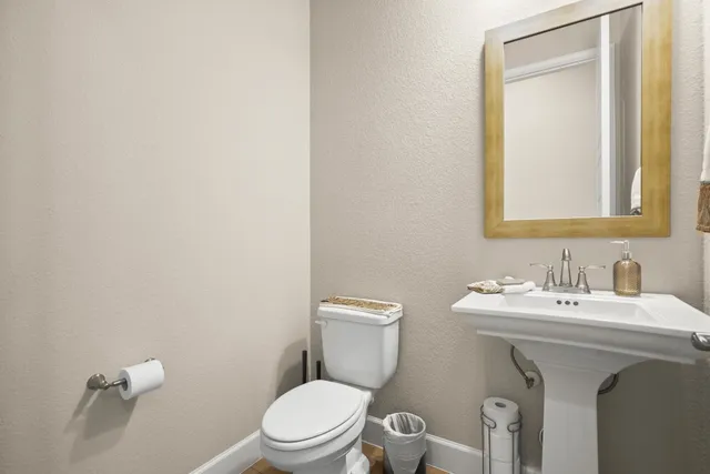 a bathroom with a toilet sink and mirror