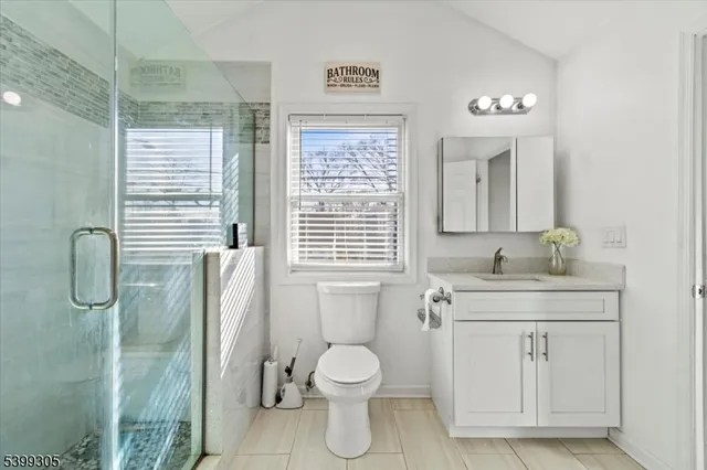 a bathroom with a granite countertop toilet a sink and a mirror