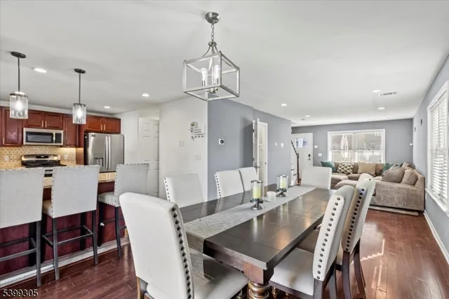 a view of a dining room and livingroom with furniture wooden floor a chandelier