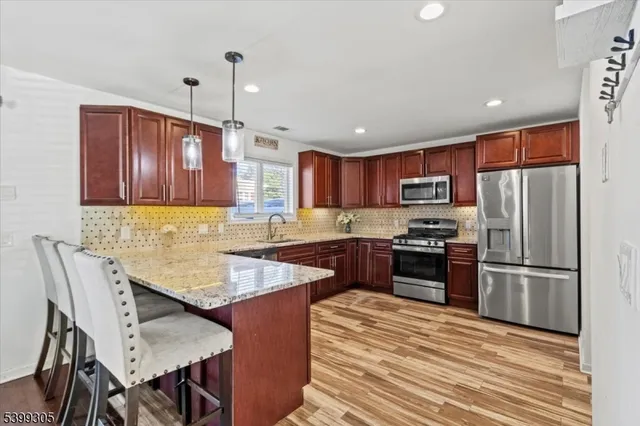 a kitchen with granite countertop stainless steel appliances and wooden cabinets