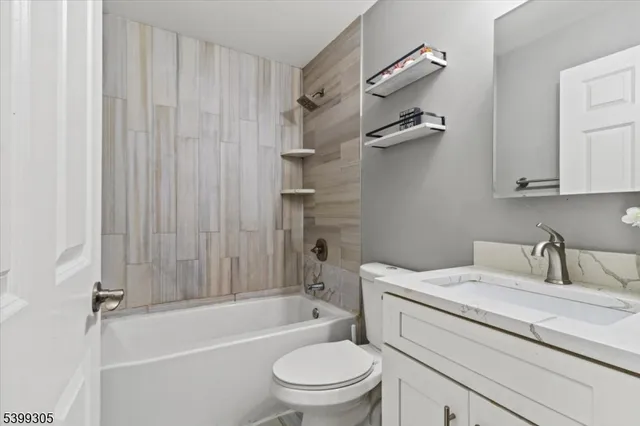 a bathroom with a granite countertop toilet a sink and a bathtub