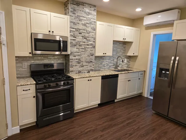 a kitchen with stainless steel appliances a stove a sink and a microwave