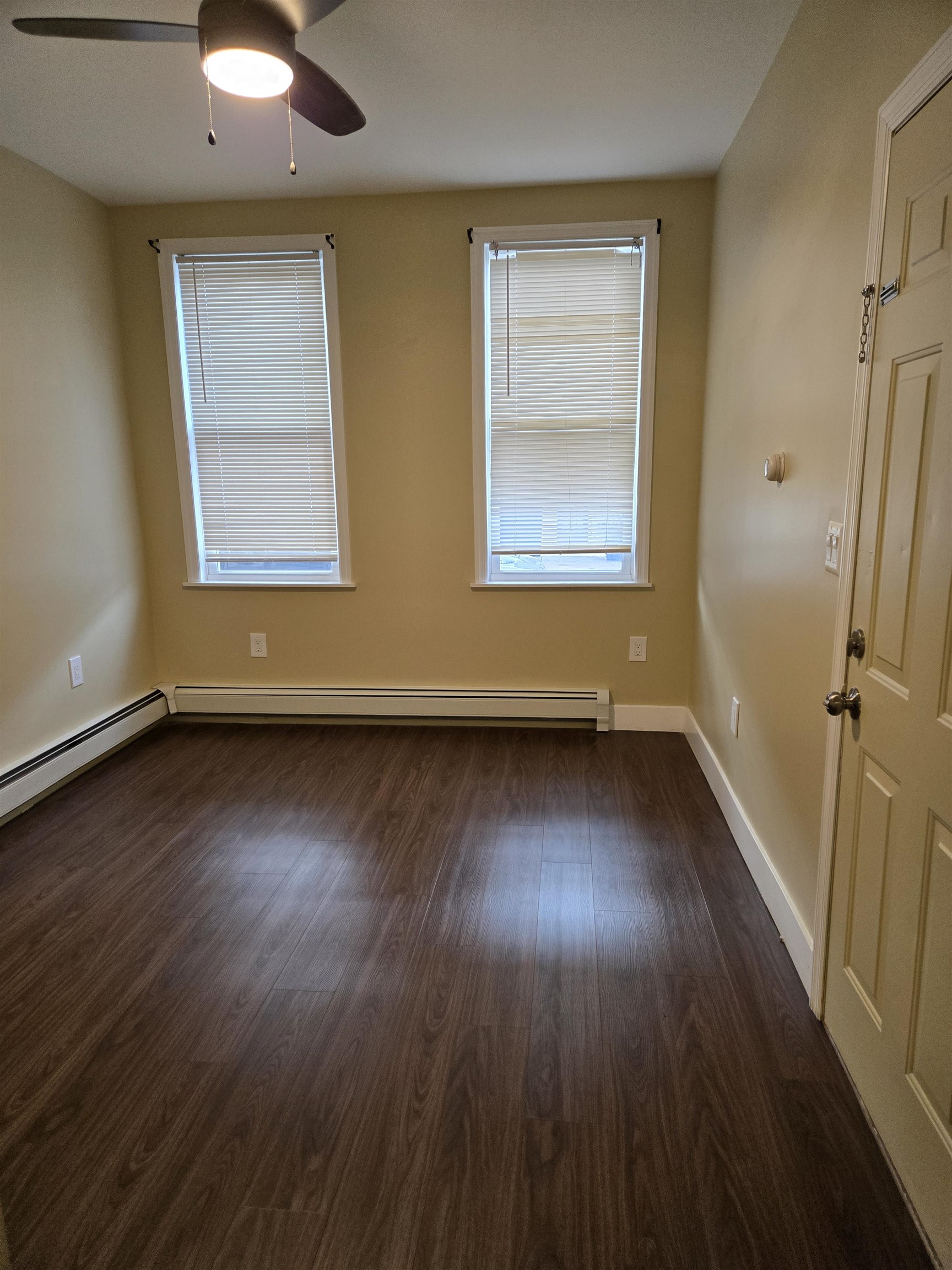 120 68th Street, Unit 1 Guttenberg, NJ 07093 - Photo 4 of 7 an empty room with wooden floor and windows
