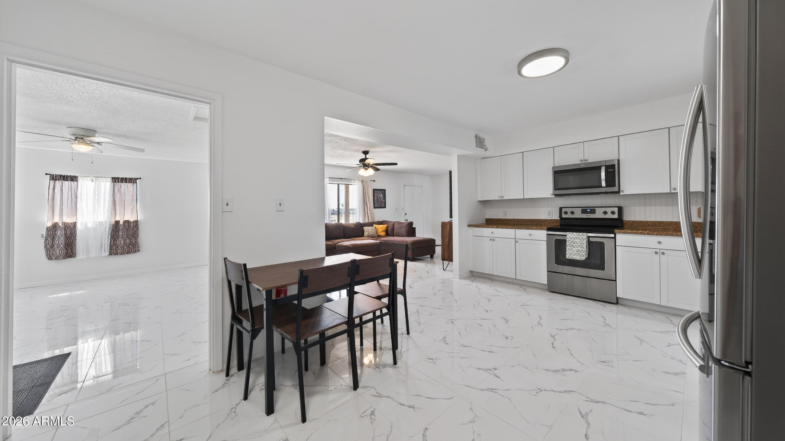 3787 North Joe Hines Road Willcox, AZ 85643 - Photo 19 of 56 a kitchen with a dining table chairs and white appliances