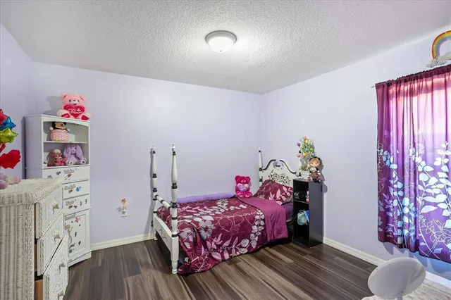a bedroom with a bed and a wooden floor