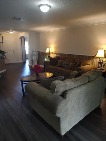 a living room with furniture and a wooden floor