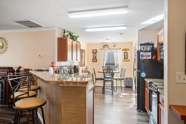 a kitchen with sink refrigerator dining table and chairs