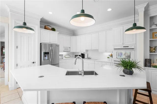 a kitchen with stainless steel appliances a table and chairs in it