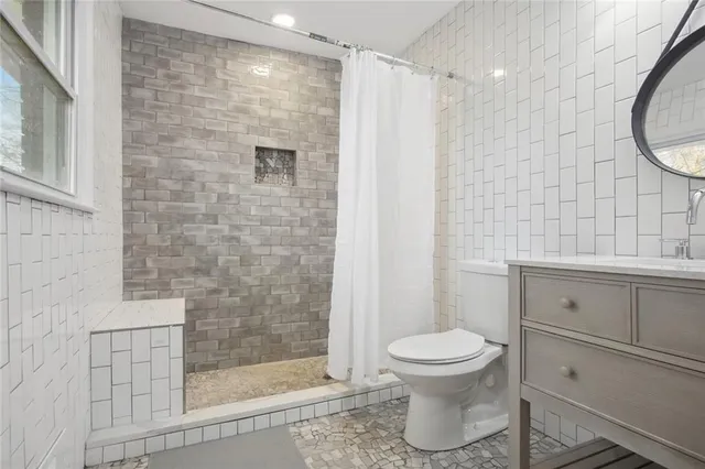 a bathroom with a toilet and a shower
