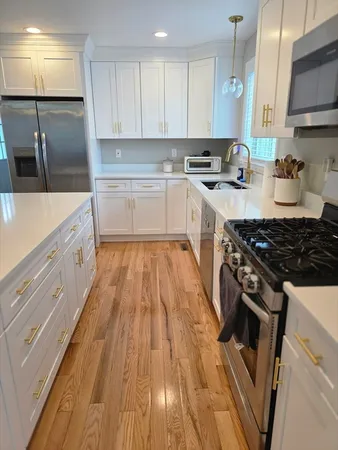 a kitchen with wooden floors and appliances