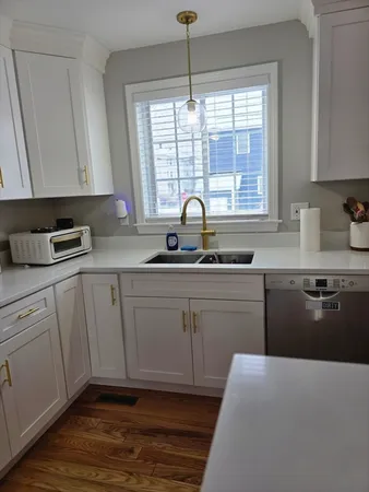 a kitchen with a sink window and cabinets