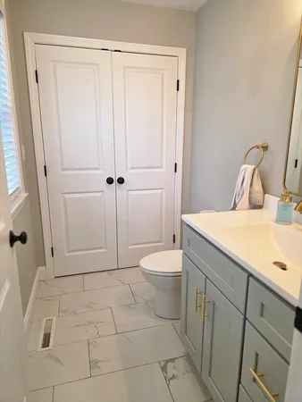 a bathroom with a granite countertop sink a toilet and a shower