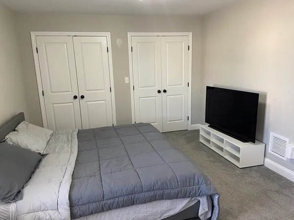 a bedroom with a bed and a flat screen tv