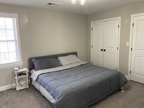 a bedroom with a bed and a window