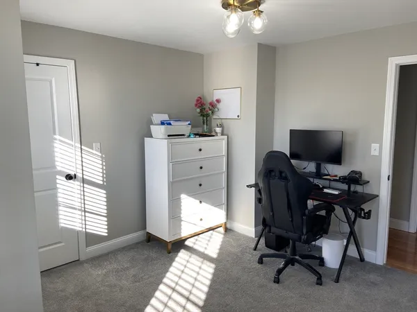 a view of a workspace with furniture and a window