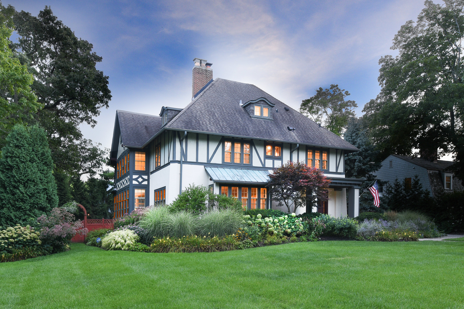 a front view of a house with a yard and potted plants