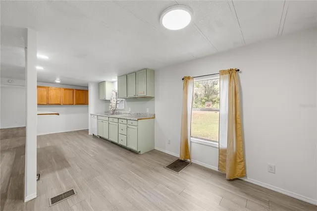 a kitchen with stainless steel appliances granite countertop a stove a sink and a large window