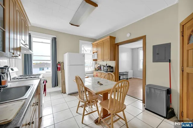 a dining room with stainless steel appliances a dining table and chairs