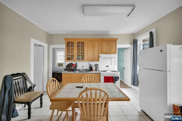 a living room with furniture and a refrigerator