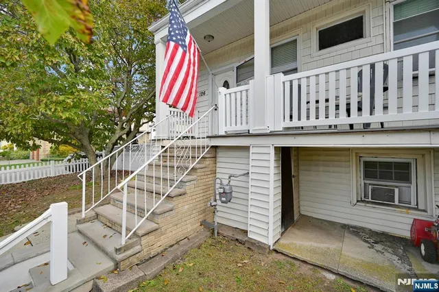 a view of wooden house with a small yard