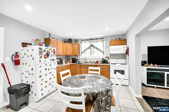 a kitchen with stainless steel appliances kitchen island granite countertop a stove a sink and a refrigerator