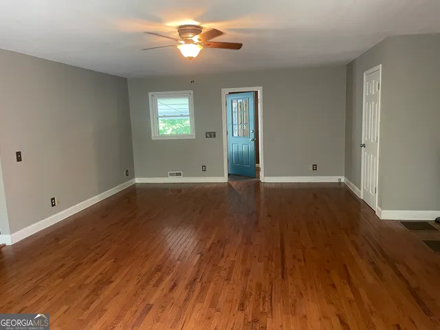 wooden floor in an empty room with a window