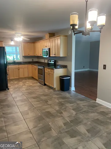 a large kitchen with granite countertop a stove a sink and a refrigerator