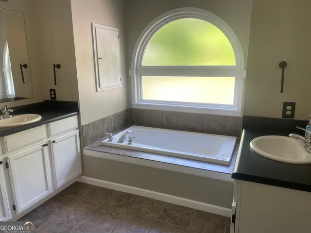 a en suite bathroom with a granite countertop tub and a sink