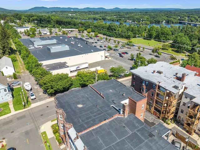 an aerial view of a house with a mountain