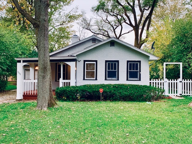 a front view of a house with a garden and plants