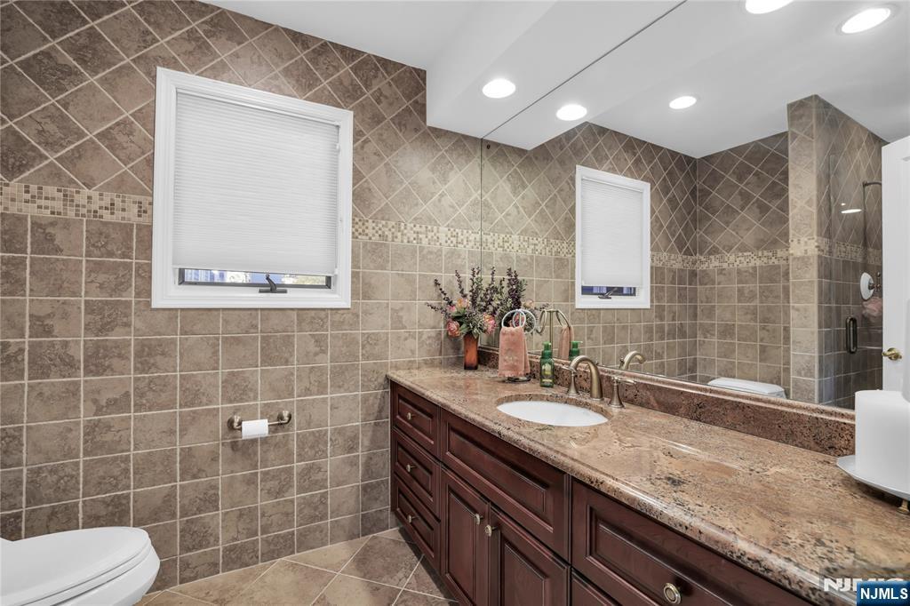 738 Ridge Road Butler, NJ 07405 - Photo 33 of 50 a bathroom with a granite countertop sink a toilet a mirror and shower