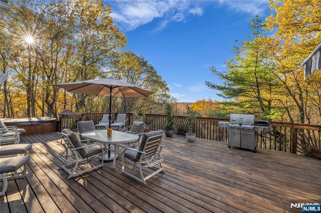 738 Ridge Road Butler, NJ 07405 - Photo 5 of 50 a view of a roof deck with table and chairs under an umbrella