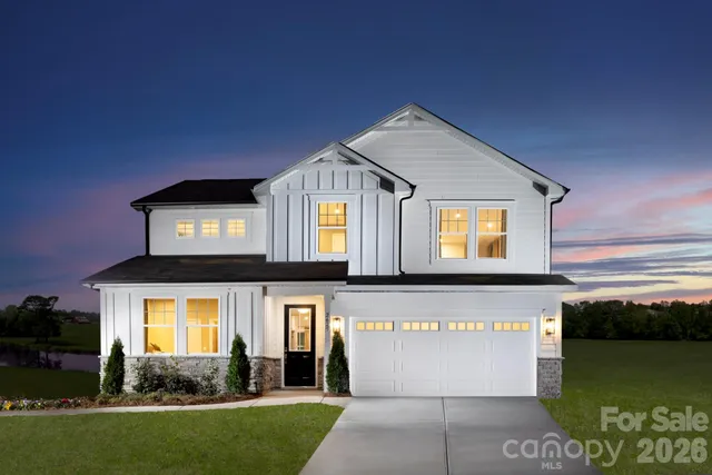 a front view of a house with a garden and plants
