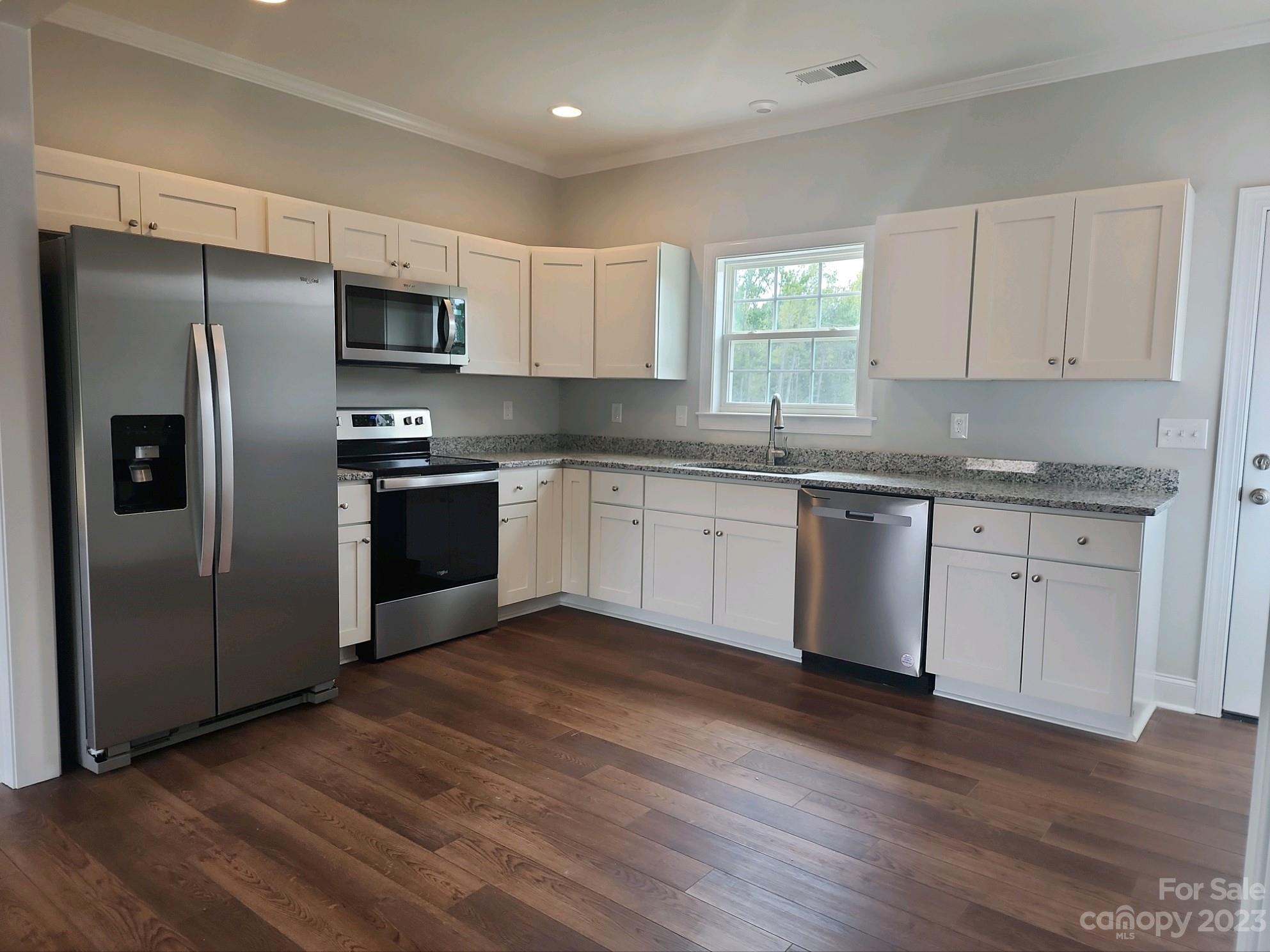767 Crow Burk Road Pageland, SC 29728 - Photo 6 of 13 a kitchen with stainless steel appliances granite countertop a stove a sink dishwasher a refrigerator and a microwave oven with wooden floor
